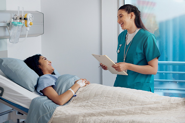 A healthcare professional supporting a patient at their bedside